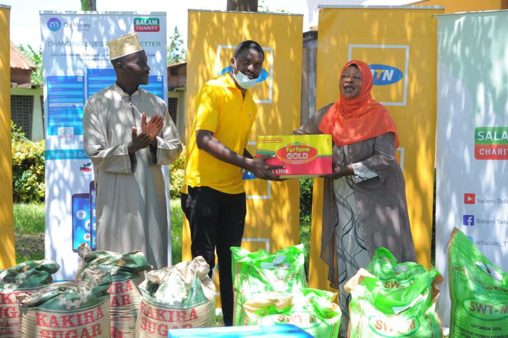 Ismail Hamwada (L) hands over to one of the leaders of the Kibuli Muslim Teachers' college