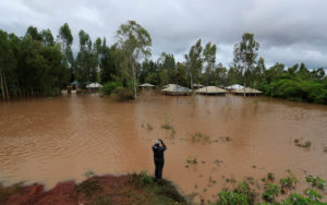 A man takes a photograph of a flooded village after River Nzoia burst its banks and due to the backflow  from Lake Victoria, in Nyadorera, Siaya County