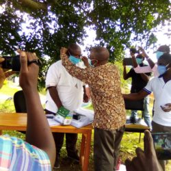 Magyezi trying put mask on the face of Bushenyi RDC Jolly Tibemanya