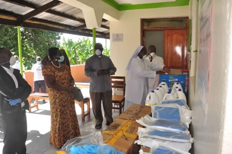 Rukiga-District-RDC-Pulkeria-Muhindo-with-others-look-at-the-Items--768x510