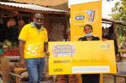 MTN's Jimmy Ssempuuma (L) hands over Emily Tumuheki's cheque