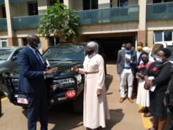 Minister Sarah Kanyike receives keys to her official vehicle from the Gender Ministry Permanent Secretary, James Ebitu on Wednesday.