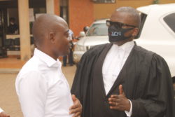 Fred Muwema (R) the lead counsel for Hamis Kiggundu speaking to his client after the court session on Friday (1)