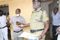 Kamuli DPC Madiri and RDC Mutemo displays some of the dollar exibts recovered from the suspects (1)