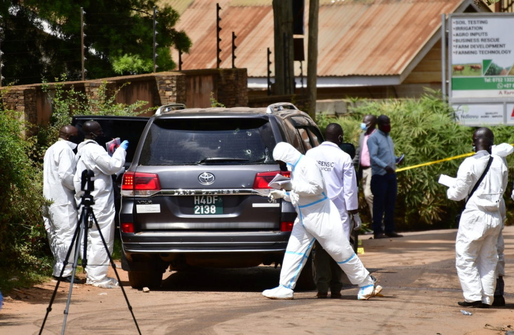 Forensic experts secure the scene of an attempted assassination on Ugandan minister of works and transport General Katumba Wamala, in the suburb of Kiasasi within Kampala