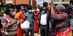 Prime Minister Robinah Nabbanja issues a mosquito net to one of the market vendors at Kalerwe