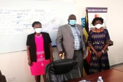 Opok (L) and Prof. Dranzoa (R) join Mike Agondoa, the cultural Chief of Ayivu in a group photo after the dissemination meeting on Tuesday