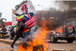 A supporter of Bobi Wine carries his poster during recent protests. Phot By Badru KatumbaAFP
