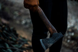 A man holds an axe in his hands against