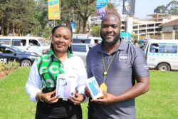 M-KOPA's Brenda Nambalirwa (L) and MTN Uganda's Ian Mugambe display some of the phones that people can access and pay for in installments while enjoying free daily MTN data for a year (1)