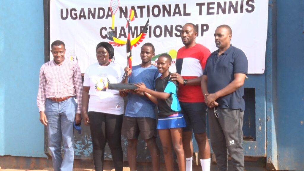 Frank Tayebwa (3L) and Winnie Birungi (3R) hoist the Uganda National Tennis Championship accolade in the company other stakeholders.