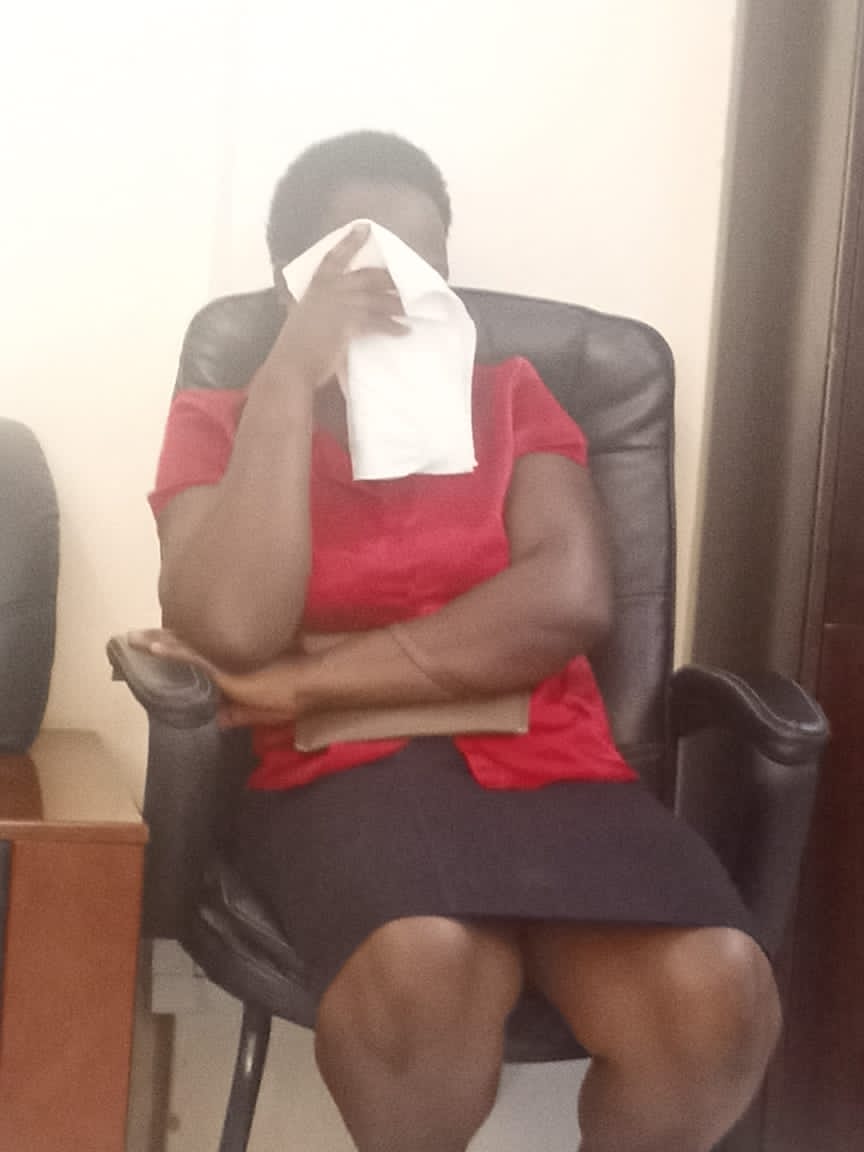 Treasure Birungi at Mbarara RRH Administration offices trying to hide her face