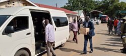 Maracha District Engineer, Timothy Ezati carries a box containing his belongings in to the State House van