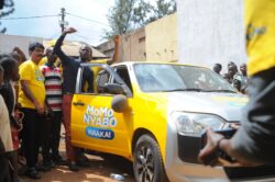 Okoth Augustine from Mbale happily makes his way into his brand new Toyota Succeed Car from MTN MoMo