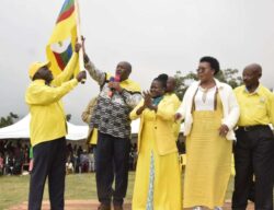 Dr. Chris Baryomunsi handsover the flag Kwizera wagahungu flanked by Kyatuhaire