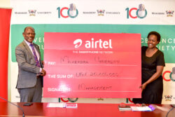 Professor Barnabas Nawangwe, (R), Vice-Chancellor Makerere University, and Flavia Lwanga, (L), Director Human Resources at Airtel Uganda, holding a dummy check during the Makerere Centenary celebrations.