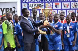UYFA Chairman Roberts Kiwanuka hands over the girls winners trophy to CBI Sports. (1)