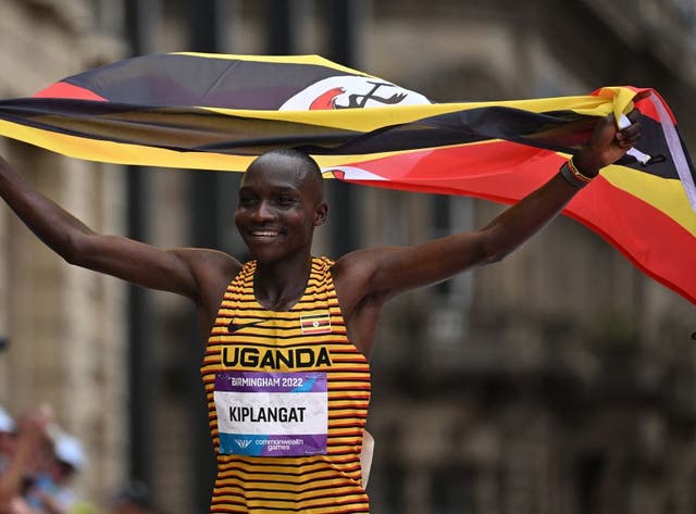 Victor Kiplangat hoists the Uganda flag. (Getty Images)