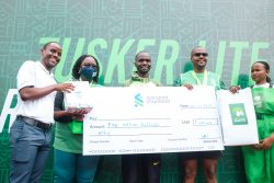 Andiema, middle is flanked by marathon sponsor and partner representatives as he displays a dummy cheque on the podium.