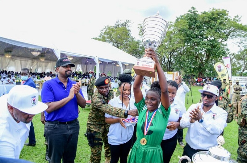 Gen. Muhoozi (2L) claps as the Nebbi Municipality Netball team captain lifts the MK tournament trophy on Saturday
