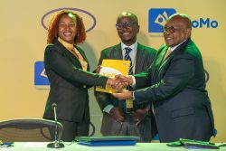 The New MTN Uganda CEO, Sylvia Mulinge (L) receives tools of office from the Board Chair, Charles Mbiire (L). (C) is the MTN Uganda CFO, Andrew Bugembe.