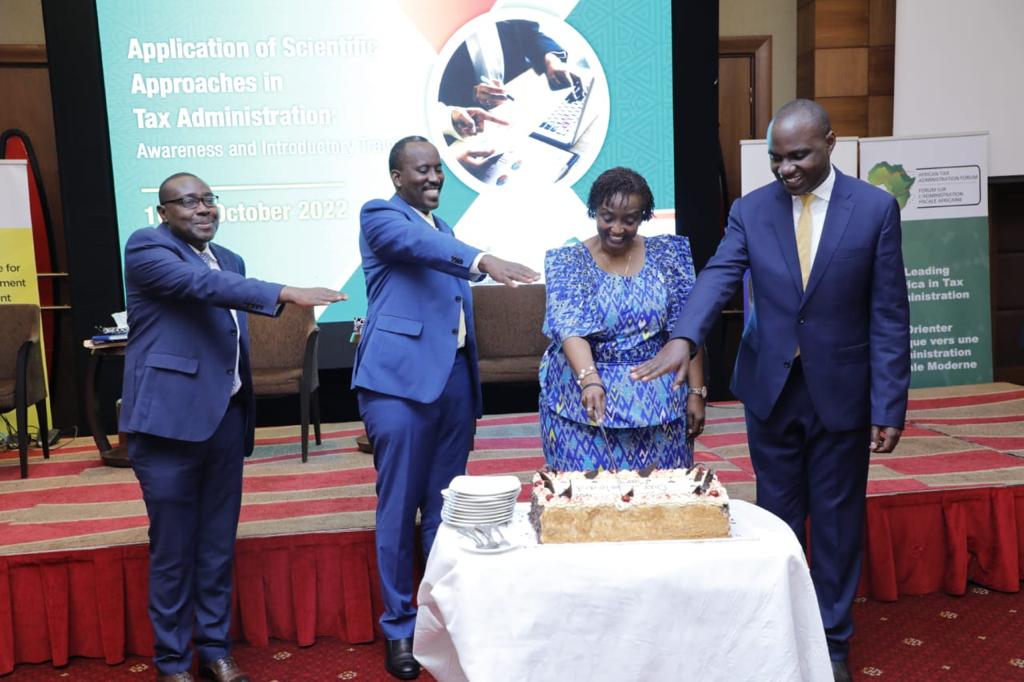 URA CG John Musinguzi, ATAF ED May Baine and Minister Henry Musasizi cutting the cake