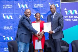Entebbe Club Chairman, Jacob Byamukama (L) and I&M Bank Acting Managing Director, Sam Ntulume (R) display MoUs as I&M Bank Head of Marketing & Corporate Communication, Annette Nakiyaga looks on.