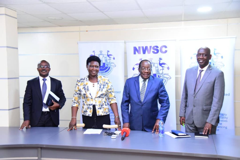 Eng.Mugisha (L) all smiles after Kiggundu's (2nd R) NWSC led board handed hima third term