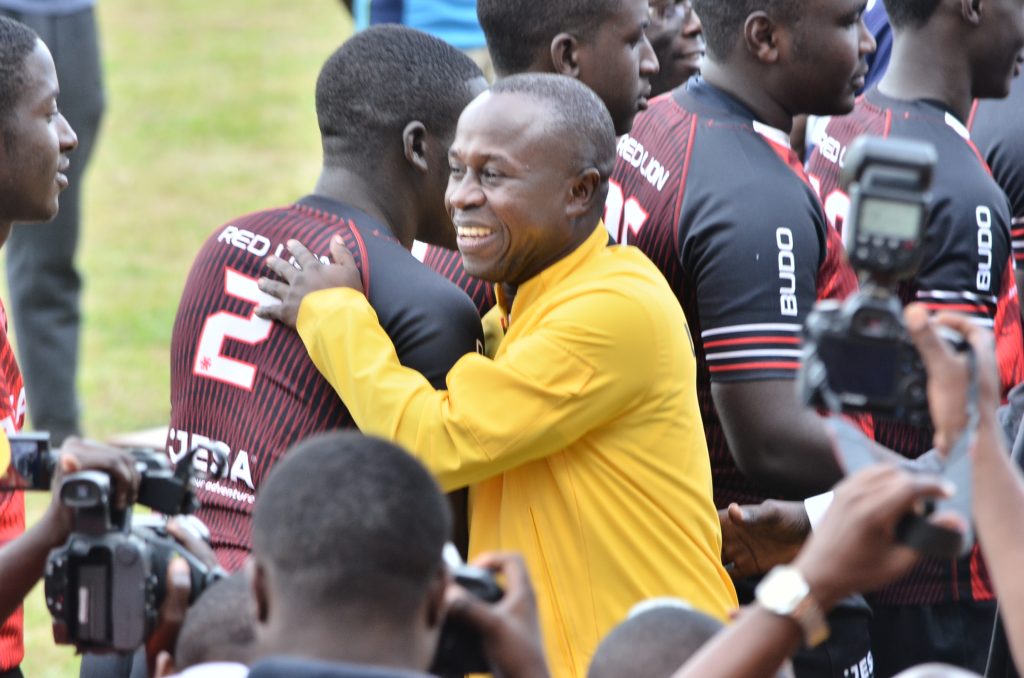 Peter Ogwang, the sports minister hugs a rugby player from Kisubi at the opening ceremony