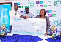 Sarah Siryowe, the General Manager of Liaison Uganda (right) hands over a dummy cheque to Kinyara representatives