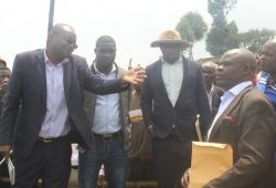 Elly Mucunguzi the Rubanda District Principal Assitant Secretary ( L) explains to Stephen Kamugisha ( R) as Patruick Abanaite the Muko LCIII chairman in hat looks on