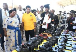 Prime Minister Robina Nabanjja (L), State House Comptroller Jane Barekye (in yellow) and other leaders inspect some of shoe products made by the youths at Bunyoro Zonal hub in Masindi district on Sunday. P