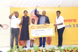 Joanita Menya, Chief Commercial Officer at Vivo Energy Uganda (R) handing over a dummy cheque to some of the winners