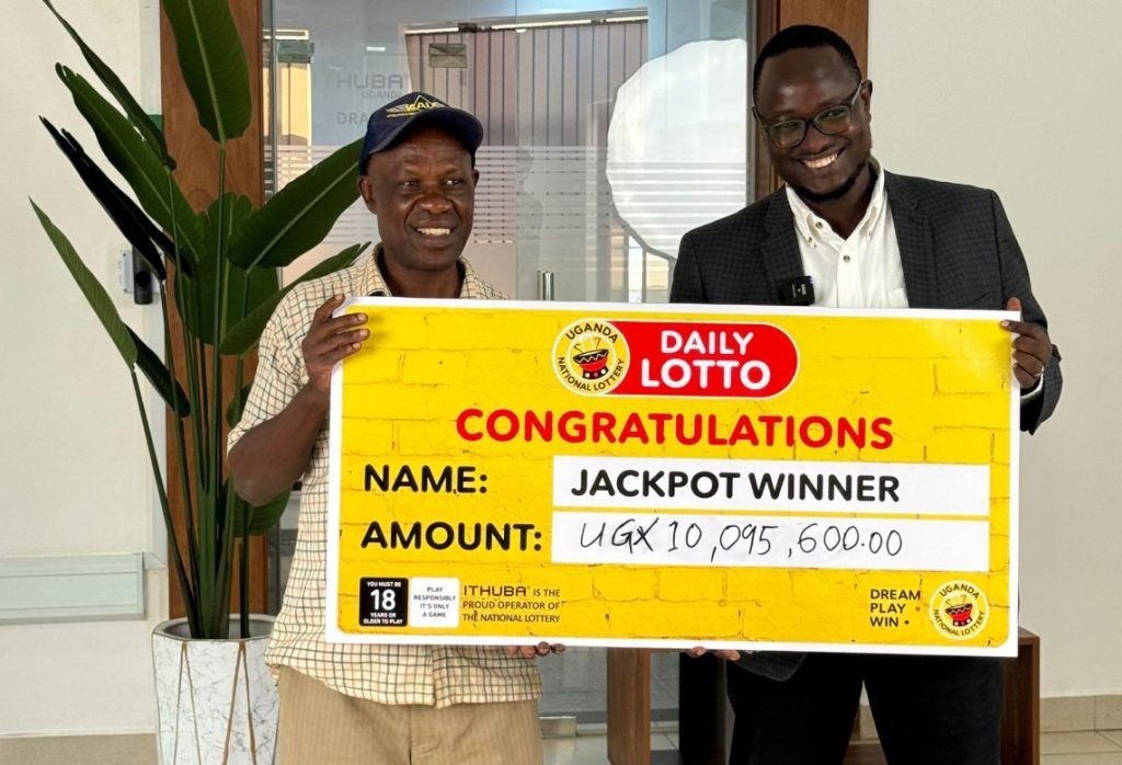 George William Kyakuwa Kibirige receives his cheque from Stephen Muneza PRO Uganda National Lottery