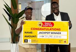 George William Kyakuwa Kibirige receives his cheque from Stephen Muneza PRO Uganda National Lottery