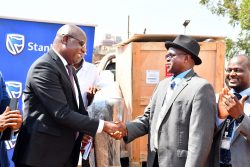 Stanbic Uganda Holdings Limited Chief Executive Francis Karuhanga shaking hands Handing over the donated equipement to the Naguru Hospital Dr Emmanuel Tugaineyo and Dr Bagala John Paul from MoH (1)