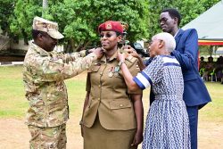 Brig General Asaf Mweteise the SFC deputy Commander pipping Lt. Col Betty Agaba during the pipping ceremony at Entebbe on Friday. PPU Photo.