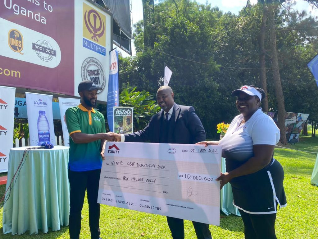 Equity Bank Uganda Managing Director Anthony Kituuka (C) hands UGX10 milion dummy cheque to Pastor Edward Mwesigye (L) at Uganda Golf Club in Kitante during the Press Launch on Wednesday