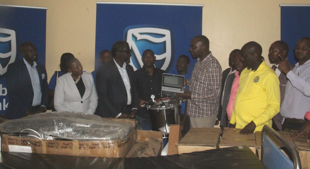 Stanbic bank MD MWOGEZA handsover to Minister Musasizi flanked by rubanda leaders