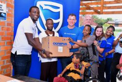 Tich Makonese, the Stanbic Bank Head of Insurance handing over the part of assortment to the Gem Foundation team.