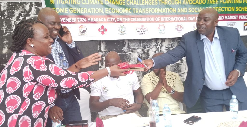 James Tweheyo handing over a praize to Mwijuka the President WIENU