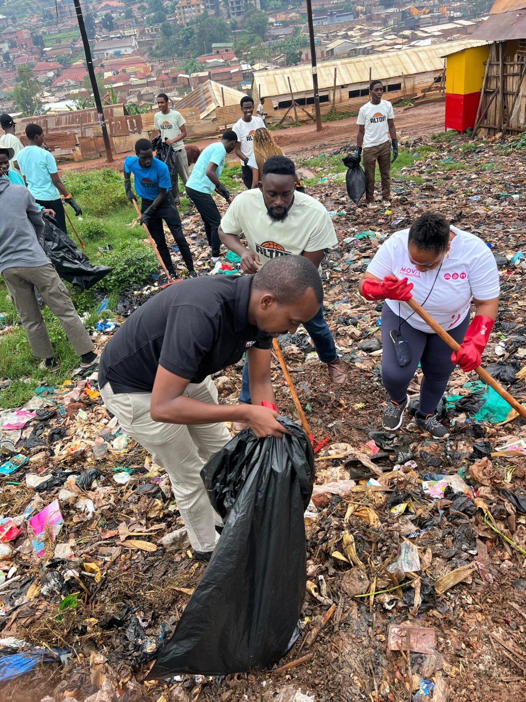 Musa Abdul Rugumayo (in black tshirt), and other participants during the cleaning exercise of Acholi Quarters on Thursday.
