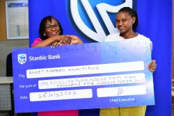 Sarah Nankumba, the Stanbic Acacia branch manager handing over a dummy cheque to Akugizibwe Annet Mbabazi, One of the lucky winners in the kyadouble with Supa Dupa campaign
