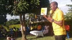 Bamuturaki showing his supporters the manifesto book which was given by the NRM party chairman c