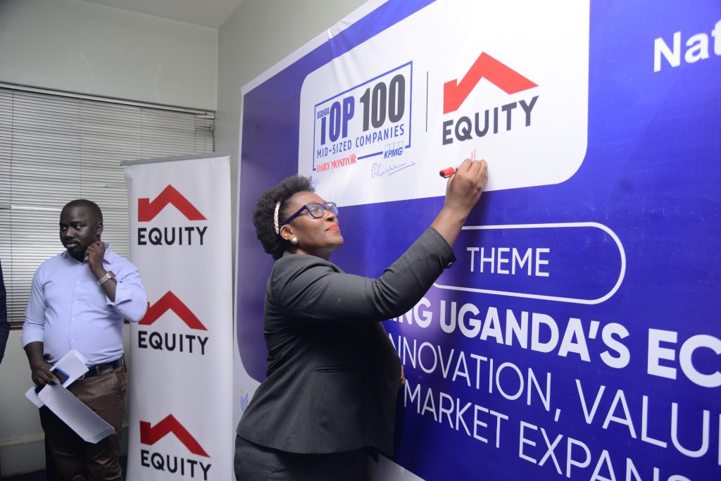 Olivia Mugaba Head SME Equity Bank signs on the launch banner at the launch of the Top 100 SME Survey 2026