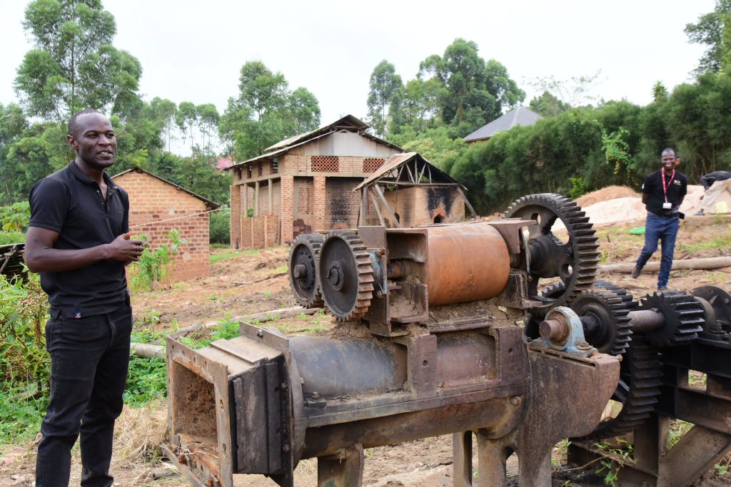 Osward Kakande showing one of the production machines used to make the stoves