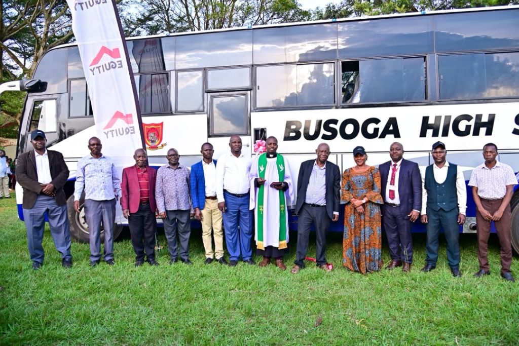 Busoga High School kamuli administration, the Equity Bank Jinja Branch manager, the Municipal Education Officer a religious leader pose for a group photo infront of the brand new bus during the hand