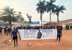Rugby fans pose with a placard for the Sydney Gongodyo Memorial Walk