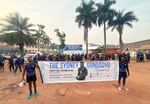 Rugby fans pose with a placard for the Sydney Gongodyo Memorial Walk