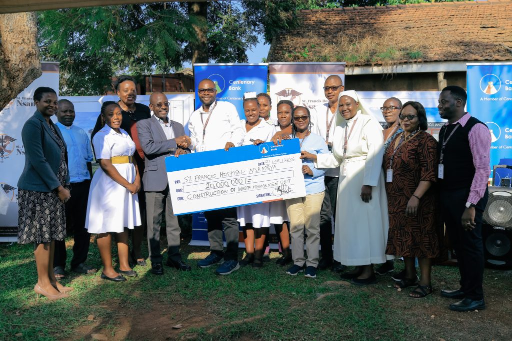 Centenary Bank MD, Godfrey Byekwaso handing over the Cheque to St Francis Nsambya hospital representatives